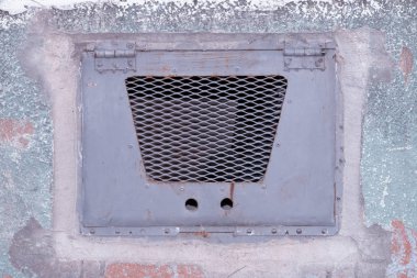 Terk edilmiş bir binanın duvarında eski metal kapak.