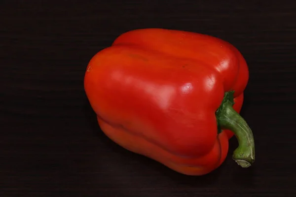 Hala yemek ile hayat. Bir büyük tatlı Bulgar kırmızı biber koyu bir arka planda masada yatıyor.