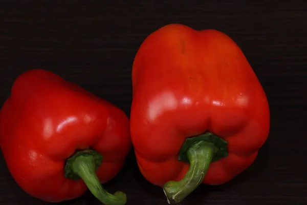 Hala yemek ile hayat. Karanlık bir arka planda iki tatlı kırmızı biber.