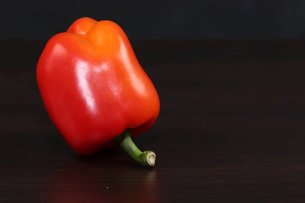 Hala yemek ile hayat. Bir büyük tatlı Bulgar kırmızı biber koyu bir arka planda masada yatıyor.
