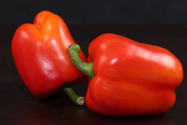 Hala yemek ile hayat. Karanlık bir arka planda iki tatlı kırmızı biber.