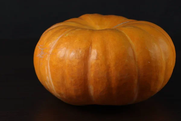 Hala sebze yiyecekleri olan bir hayat. Kapat şunu. Koyu arka planda masada büyük Olgun Turuncu kabak.