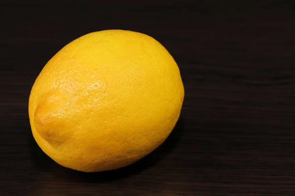 Narenciye. Karanlık bir masada olgun limon yakın çekim.