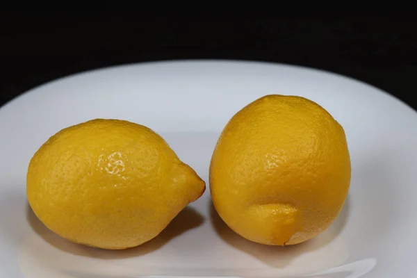 Narenciye. Beyaz servis plakasında limonlar yakın çekim.