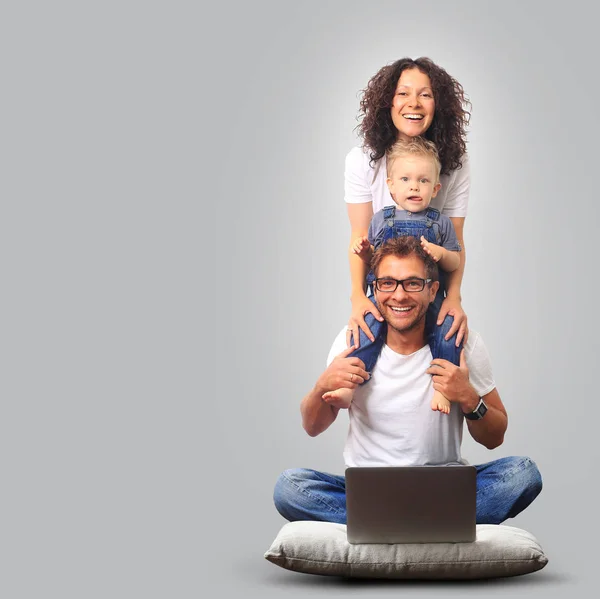 Happy young family laughing and smiling on light background