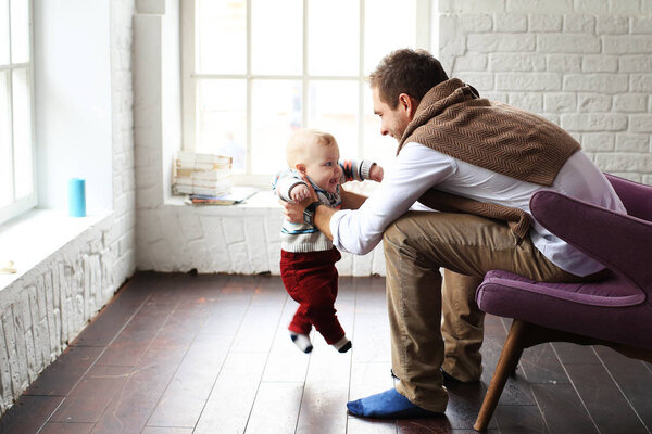 Father and little son play in home