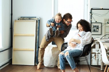 Mutlu genç aile gülüyor ve evde dans
