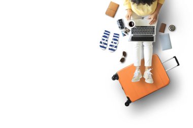 Turist konsepti, dizüstü bilgisayarı olan bir kız ayaklarını bavula koydu.