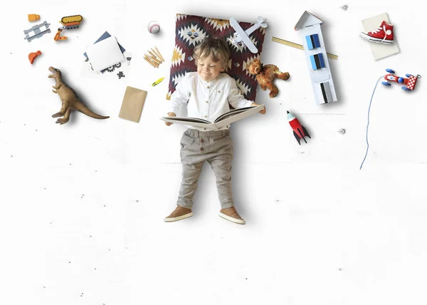 Pequeño Niño Lindo Mintiendo Leyendo Libro Entre Sus Juguetes — Foto de Stock