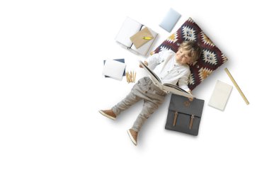 Küçük çocuk oturup oyuncaklarının arasında yerde oynuyor.