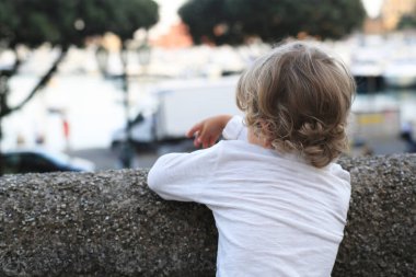 Güzel kıvırcık saçlı çocuk İtalya 'daki sete bakıyor.