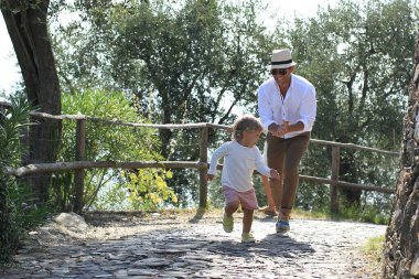 Babam parkta küçük sevimli bir çocuğun peşinden koşuyor.