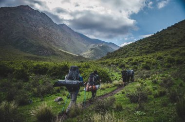  Bir grup insan yeşil dağların arasında yürümek.