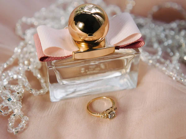 Engagement ring and a perfume, gold, white and pink colors, beaytiful wedding details, bridal morning