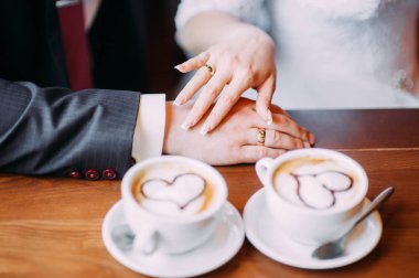 Düğün konsepti. Gelin ve damat kahve içerken el tutarak