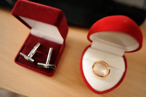 collar buttons and wedding ring in red boxes