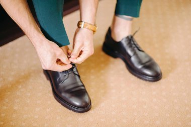 ayakkabı bağcığı, damat düğün töreni için hazırlanıyor ipe yeşil elbiseli şık adam