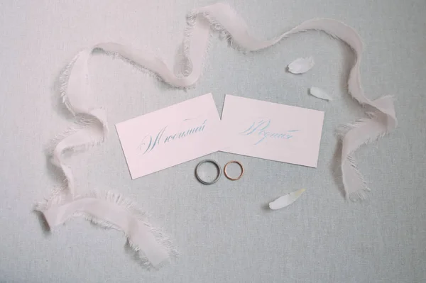 set of wedding calligraphy cards, wedding rings and ribbon
