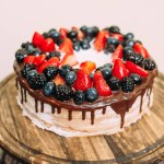 Torta nuziale luminosa decorata con frutta e bacche