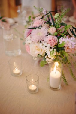 Masa üzerinde ihale çiçekler ve mumlar ile zarif buket