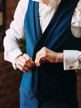 koyu mavi takım elbise giyen şık adam, damat düğün töreni için hazırlanıyor