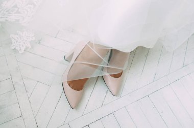  gelinliği beyaz gelinlik ve pembe ayakkabı giyiyor 