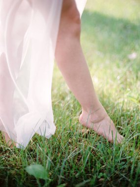 beyaz gelinlik yalınayak gelin bahar çim üzerinde yürüyüş