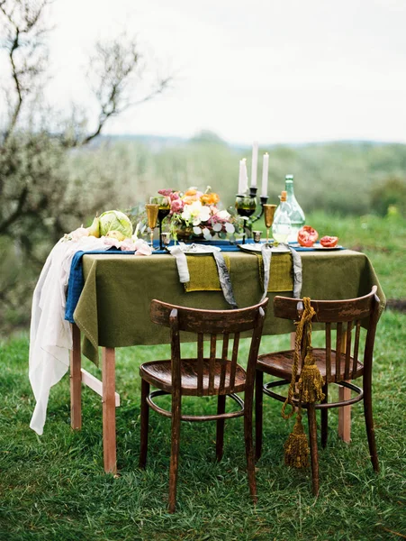 elegant bouquet, candles and food on table outdoor
