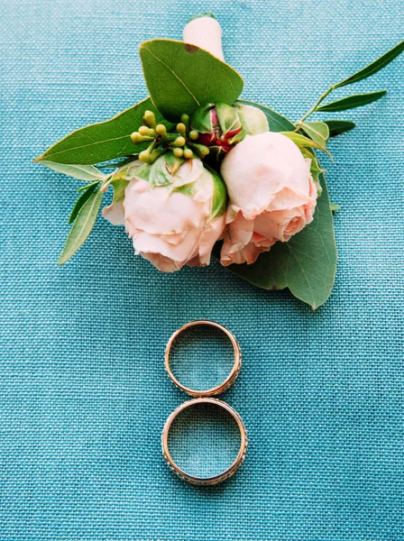Golden wedding rings and pink flowers, eternal love concept