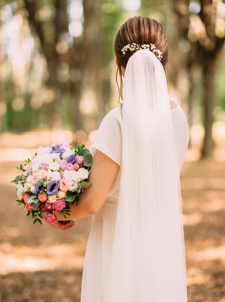 白いドレスで花嫁は柔らかい花で結婚式の花束を保持し バックビュー — ストック写真