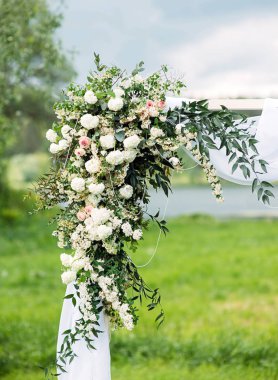 Düğün kemeri çiçek süslemesi, beyaz güllerin kemeri yeşil çimlere yakın, kırsal düğün töreni, mavi gökyüzü, açık havada bahçede düğün..