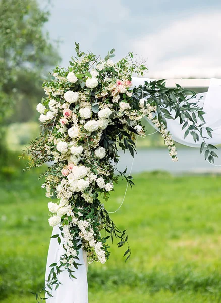 Düğün kemeri çiçek süslemesi, beyaz güllerin kemeri yeşil çimlere yakın, kırsal düğün töreni, mavi gökyüzü, açık havada bahçede düğün..