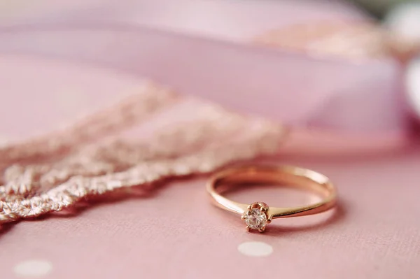 Nişan yüzüğü, pembe arka planda bir elmasla yakın plan. Sonsuz aşk kavramı