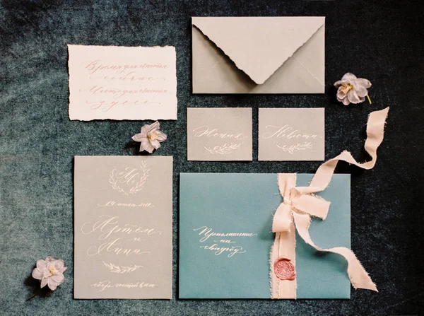暗い灰色の背景に結婚式の招待状や書道カード 桃のリボンや花のセット トップビュー フラットレイアウト — ストック写真