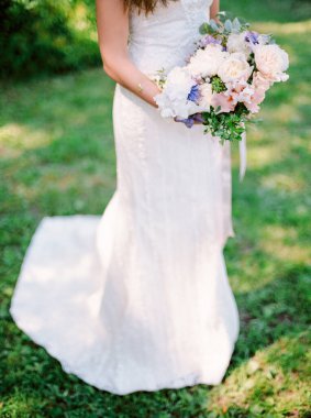 Şık bir gelin buketi. Bahar ya da yaz düğünü. Güzel bir düğün konsepti. Yeşil arka plan. Parkta açık hava töreni..