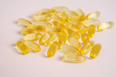 Balık yağı kapsülleri yakın plan. Omega beslenme, nötr zemin üzerinde vitamin hapları. Vegan sağlık hizmetleri için tıbbi destek hapları ve metin için boş alan.