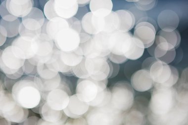 Koyu mavi arka planda beyaz bokeh ışıkları, soyut minimalizm kavramı.