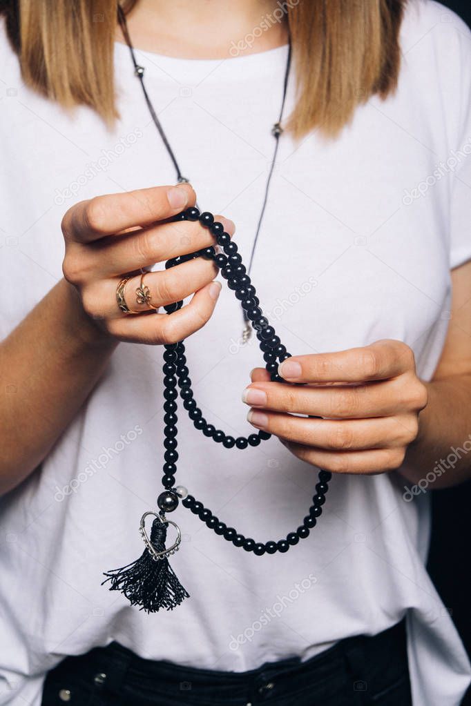 Black beads bracelet in girl hand. Can be used as fashion accessories, also as praying beads, for counting prayers or practicing mindfulness meditation. Some believe black stone has protection power