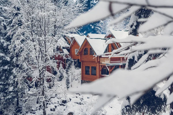 Wooden cottage holiday house in mountain holiday resort covered with fresh snow in winter