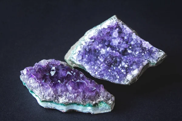 Nahaufnahme von Amethyst-Drusenkristallen auf einer Platte aus dunklem Granit. Textur von Kristallen aus Amethyst. Amethyst Kristalle geologischen mineralischen Hintergrund. Selektiver Fokus — Stockfoto