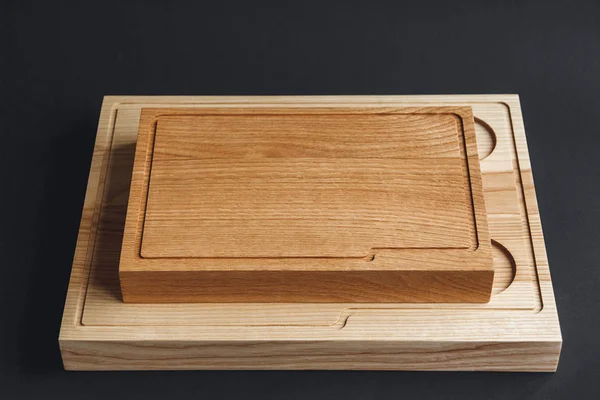 Tagliere in legno di noce fatto a mano su tavola di legno nero — Foto Stock