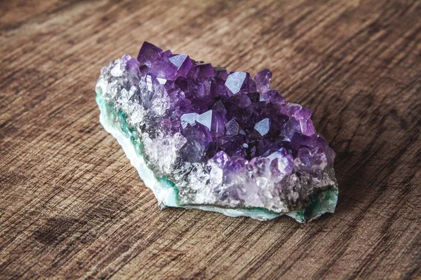 Nahaufnahme von Amethyst-Drusenkristallen auf einer Platte aus dunklem Granit. Textur von Kristallen aus Amethyst. Amethyst Kristalle geologischen mineralischen Hintergrund. Selektiver Fokus — Stockfoto