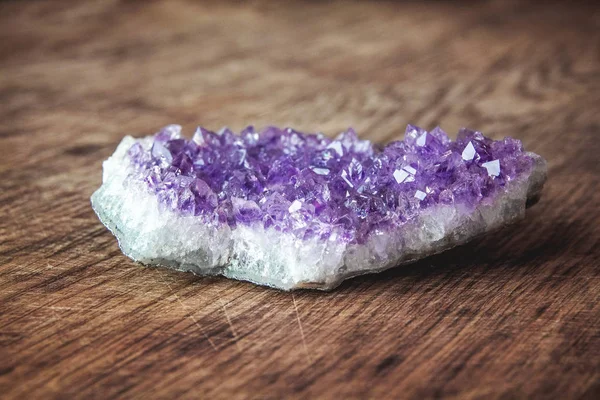 Close-up of amethyst stone druse crystals on dark granite polished slab. Texture of crystals of amethyst. Amethyst crystals geological mineral background. Selective focus — Stock Photo, Image