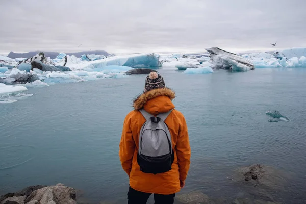 Man står på en is i en glacier lagoon Glaciärlagunen Island under en vacker solig dag — Stockfoto