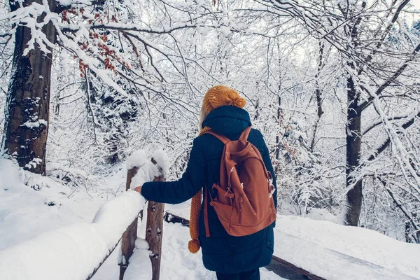 Una joven está dando un paseo por un bosque espeso durante un hermoso día de invierno. — Foto de Stock