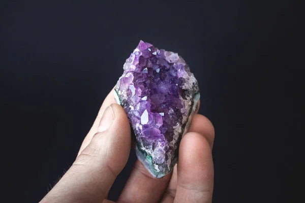 Druso di cristalli viola naturali non trattati di ametista su un pezzo di roccia si trova sul palmo della mano — Foto Stock