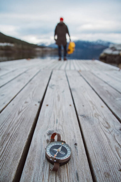 old compass on a wooden background with a human figure