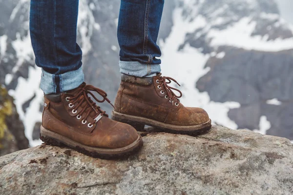 Het volgen van laarzen voor een wandeling en avontuur op een stenen achtergrond. Travel lifestyle concept. — Stockfoto