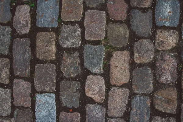 The texture of the old cobblestone and unusual stones. Patterned paving tiles cobblestone road for texture. Top view. Copy space. Can use as banner — Stock Photo, Image