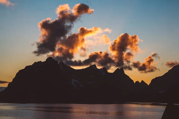 Sunset over the mountains by the sea. Silhouette of the mountains. Beautiful clouds — Φωτογραφία Αρχείου